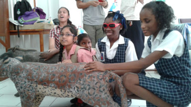 Students of the Ministry of Education’s Visually Impaired Unit familiarizing themselves with a life size representation of a jaguar during an interactive session with a team from the Iwokrama International Centre. 