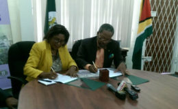 Minister of Public Telecommunications, Catherine Hughes and  Vice Chancellor of the University of Guyana, Professor Ivelaw Griffith signing the MoU.   