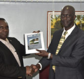 Commissioner of the Guyana Lands and Surveys Commission Trevor Benn (right) receives a copy of the draft Sustainable Land Development Project from Food and Agriculture Organisation Representative Reuben Robertson