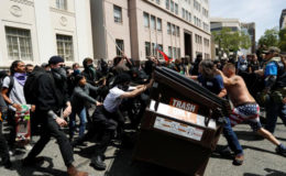 Demonstrators for (R) and against (L) US President Donald Trump push a garbage container toward each other during a rally in Berkeley, California in Berkeley, California, US, April 15, 2017. (Reuters/Stephen Lam )