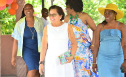 First Lady Sandra Granger (second, left) is ushered into the garden at the Critchlow Labour College by Director of Women Across Differences (WAD) Clonel Samuels-Boston (right) yesterday. 