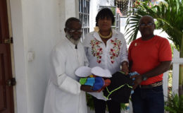 Waveney Benn, centre, athletic coach Leslie Black, right, and Monsignor Terrence Montrose of the Church of the Immaculate Conception display some of the equipment.