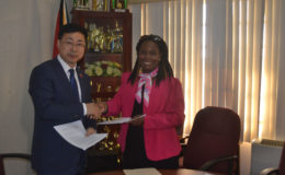 Permanent Secretary (ag), Ministry of Agriculture,  Joylyn Nester-Borrowes (right) and  Counselor, Economic and Commercial Officer, Chinese Embassy, Shen Huiyong shaking hands on the deal. (Ministry of Agriculture photo)
