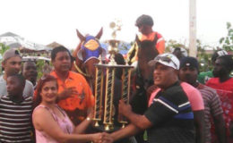 Handlers of Royal Prince accepts the spoils of the L Non Earners trophy on Sunday at the Kennard Memorial Turf Club