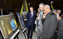 President David Granger (right) observes one of the photographs that were part of the display at the reception