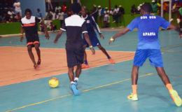 Omallo (centre) Williams of North East La Penitence on the attack while being watched closely by Devon Millington (right) and Sheldon Shepherd (2nd from right) of Sparta Boss in the Petra Organization Futsal Championship quarterfinal round at the National Gymnasium. (Orlando Charles photo)