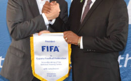 FIFA President Giovanni Infantino (left) hands over the commemorative badge to GFF President Wayne Forde following the end of his four hour visit to Guyana yesterday at the Le Meridien Pegasus Hotel.