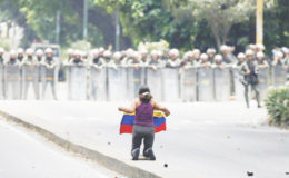 A demonstrator knees in front of riot police during a rally against Venezuela’s President Nicolas Maduro in Caracas, Venezuela April 20, 2017. REUTERS/Carlos Garcia Rawlins 