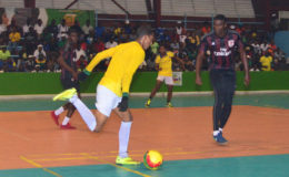Flashback-Desmond Cottam (yellow) of Sophia initiating an attack while being watched closely by Colin Nelson of Bent Street at the National Gymnasium in the Petra Organization Futsal Championship group round