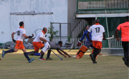 Ato Greene (center) of St Stanislaus being denied by GCC’s Medroy Scotland during their Farfan & Mendes men’s first-division league match at the GCC ground, Bourda on Sunday.