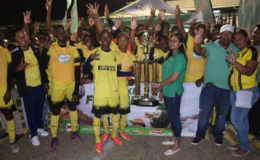 Three-Peat! The victorious Chase Academy unit posing with the championship trophy alongside M.Beepat and Sons Marketing Manager Renita Seethal, after they defeated Morgan Learning Center (MLC) via penalty kicks to retain the Milo Secondary School football title at the Ministry of Education ground, Sunday night. (Orlando Charles photo)