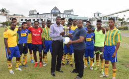 Petra Organisation Co-Director Troy Mendonca  (right) presenting the ball and trophy to President of Circuit Ville Youth & Sports Club President Owan Wills in the presence of club players.