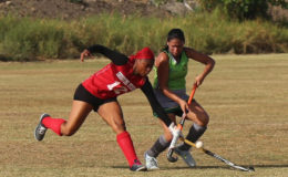 Old Fort’s Shonette Moore (left) battles with Hikers’ Maria Munroe for possession of the ball in their Woodpecker Products women’s first division hockey league matchup at the St. Stanislaus College ground, Carifesta Avenue Saturday.