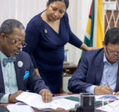 University of Guyana Vice Chancellor Professor Ivelaw Griffith (left) signing two memoranda with MovieTowne Chief Executive Officer Derek Chin for solar energy production and student housing. Looking on is Dr Paloma Mohamed, Deputy Vice Chancellor of Philanthropy, Alumni and Civic Engagement