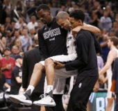 Spurs point guard Tony Parker (9) is helped off the court after being injured against the Houston Rockets (Credit: Soobum)