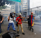 An opposition supporter plays the violin during clashes with riot police, during a rally against President Nicolas Maduro in Caracas, Venezuela, May 8, 2017. (Reuters/Carlos Garcia Rawlins)