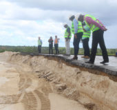 Ministers of Public Infrastructure David Patterson (at right) and Annette Ferguson (at centre) inspect works where the old airport runway meets the new expanded one currently built up with sand. (Photo by Keno George)
