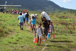 Women and Children alike came out to help with the transportation of emergency flood relief supplies after one of several flights arrived in Chenapou yesterday.
(Government Information Agency photo)