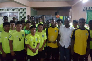 Walter Moore and Guyana Football Federation president Wayne Forde along with members of the National U17 squad.