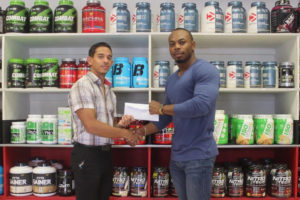 CEO of Fitness Express, Jamie McDonald presenting a sponsorship package to Emmerson Campbell yesterday.