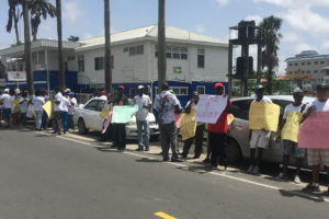 Protesters from the different mining syndicates around the country standing outside of the Guyana Geology and Mines Commission yesterday. 