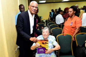 President David Granger posed for a picture with his former History lecturer, the 87-year old  Sister Mary Noel Menezes holding a copy of her book. (Ministry of the Presidency photo)