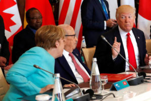 German Chancellor Angela Merkel (L) sits next to Tunisia’s President Beji Caid Essebsi (C) and speaks to U.S. President Donald Trump (R) as they attend a G7 expanded session during the G7 Summit in Taormina, Sicily, Italy, May 27, 2017. (Reuters/ Philippe Wojazer)