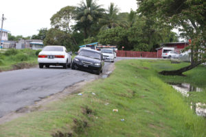 This section of road leading to the University of Guyana has begun to erode towards to the canal at right. Cars traversing it in this Keno George photograph taken yesterday, appear to be tilted in that direction. 