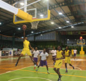 Nigel Bowen (left) of Plaisance Secondary in the process of scoring a layup against President’s College in the National Schools Basketball Festival at the Cliff Anderson Sports Hall Saturday.