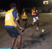 Keon Sears (right) of Dave and Celina’s All-Stars battling to evade the pursuit of several players from Young Kings during their quarterfinal fixture at the Amelia’s Ward Tarmac in the Guinness ‘Greatest of the Streets’ Linden edition Monday.