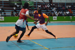 Dwayne Lowe (left) of Sophia threading a pass beyond the outstretched leg of Kennard Simon (centre) of Dave and Celina’s All-Stars, during their elimination matchup at the National Gymnasium in the Xtreme Clean/GT Beer Futsal Championships.