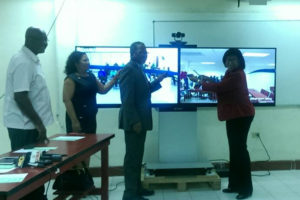 Minister of Public Telecommunications Catherine Hughes (right) cutting the ribbon at the commissioning of UG’s new Teleconferencing Platform with Vice Chancellor Ivelaw Griffith (second, right), Dr Paloma Mohamed and Head of the e-Government Unit Floyd Levi.  