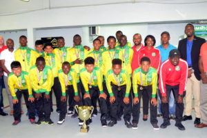  Members of the Guyana u15 national team posing with their championship trophy at the Eugene F. Correia Airport alongside members of the GFF following their return from the successful Soualiga Invitational Championship in St. Martin Tuesday night. (Orlando Charles photo)
