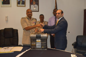 Dr. Maurice Aboud (right) making the presentation to Commissioner of Police Seelall Persaud (Police photo)