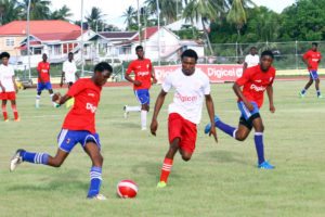 Action between Leonora Technical Institute (red) and Professional Learning Centre at the National Track and Field Centre, Leonora in the 7th Annual Digicel Schools Football Championships yesterday. (Orlando Charles photo)