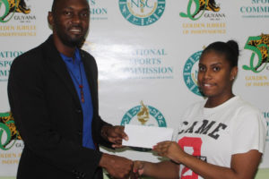 Director of Sports Christopher Jones and Junior Caribbean girls singles bronze medalist, Pricilla Greaves at the handing over ceremony, yesterday. (Royston Alkins photo)