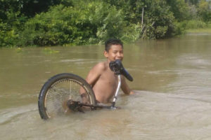 This boy attempted to lift his bicycle through the Kabanawau Creek to get to the other side as waters covered section of the access road to Aishalton Village. 