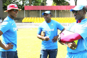 Assistant coach Stuart Williams (centre) chats with head coach Vasbert Drakes (left) and assistant coach Ezra Moseley during training. (Photo courtesy CWI Media) 