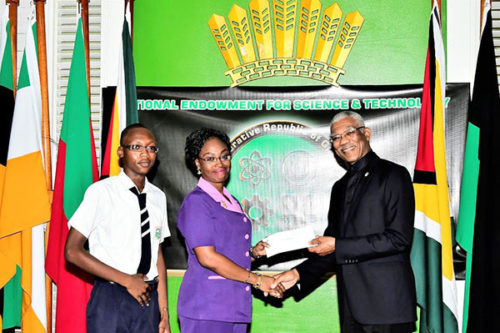Acting Head Teacher of the Berbice High School, Ayesha Wong-King and a student of the school receiving the cheque from President David Granger at State House  (Ministry of the Presidency photo)