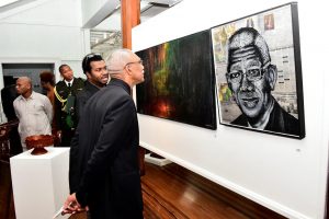 President David Granger examines a portrait of himself that was made of screws on wood and newspaper at the National Art Gallery on Thursday evening. The piece, titled ‘Chronicles of H.E. David Granger,’ was created by artist Shimuel Jones. (Ministry of the Presidency photo) 