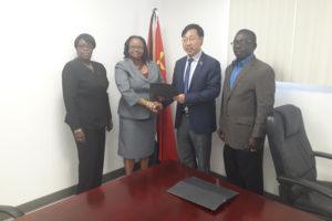 Public Health Minister Volda Lawrence (second from left)  and an official of the Chinese Embassy with the agreement. Also in photo from left are Permanent Secretary in the Ministry of Public Health Collette Adams and acting CEO of the GPHC, George Lewis. (Ministry of Public Health photo)