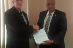 ExxonMobil Country Manager Rod Henson (left) and Minister of Natural Resources Raphael Trotman with the production licence. (Ministry of Natural Resources photo)
