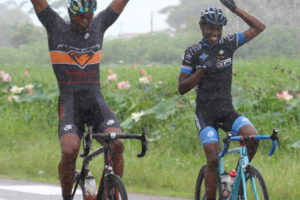 Father of 10 Warren ’40’ McKay and Brighton John celebrate in the drizzle as they victoriously cross the line as winners in the veteran and junior categories. (Orlando Charles photo)