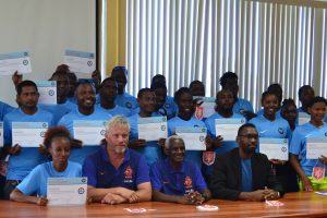The successful participants of the National Sports Commission (NSC)/Royal Dutch Football Association (KNVB) five-day training course displaying their certificates in the presence of Sports Director Christopher Jones (sitting right), KNVB representative Andre Simmelink (sitting 2nd left) and Surinamese Football Coach Kenneth Jaliens