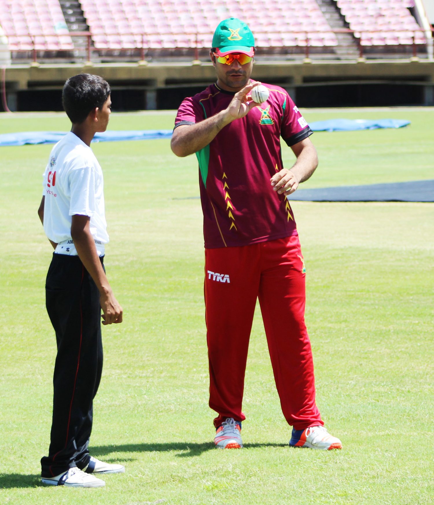Digicel’s `Big Brother’ programme in full swing as spin sensation Rashid Khan shares some bowling tips with youngster Saturday.(Royston Alkins Photo)