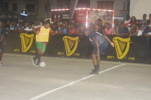 Anil Hernandez (centre) of Melanie-B on the attack against Silver Bullets during their quarterfinal fixture in the Guinness ‘Greatest of the Streets’ National Championship at the Mackenzie Bus Tarmac.