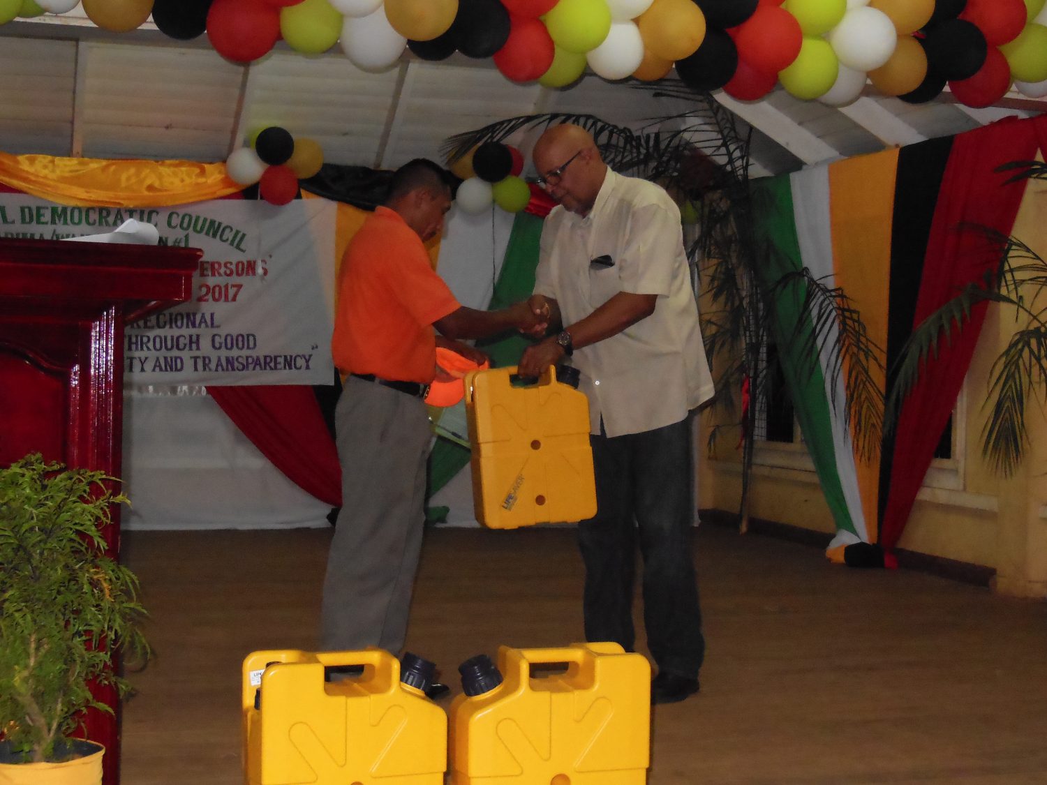 Managing Director of GWI, Dr. Richard Van West-Charles (right) presents a Jerry Can to a village leader (GWI photo)