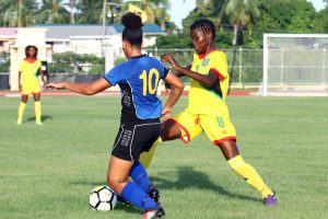 Tiandi Smith (right) of Guyana battling for possession of the ball with a Barbados player during their matchup at the National Track and Field Centre Leonora in the CONCACAF Girls u17 Qualifying Championship. (Orlando Charles photo)