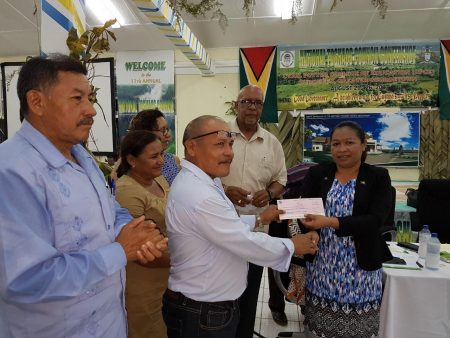 Minister within the Ministry of Communities, Dawn Hastings-Williams (right) hands over a cheque to a representative of the Paramakatoi Village Council (GWI photo)