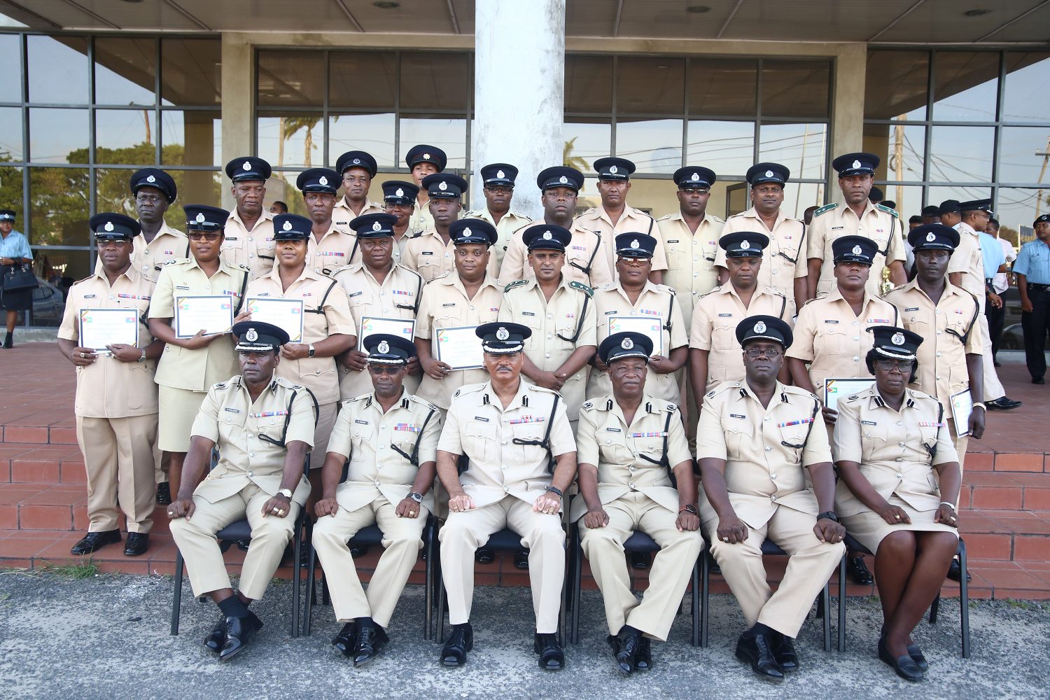 Acting Commissioner of Police David Ramnarine (seated third, from left) and other senior officers of the police force are flanked by the graduating ranks of the Junior Officer’s Course No.29 (Keno George photo) 